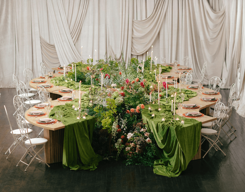 Dinner tablescape with green linens and floral arrangements